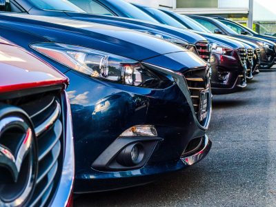 cars lined up at a car dealership that processing payments via ach