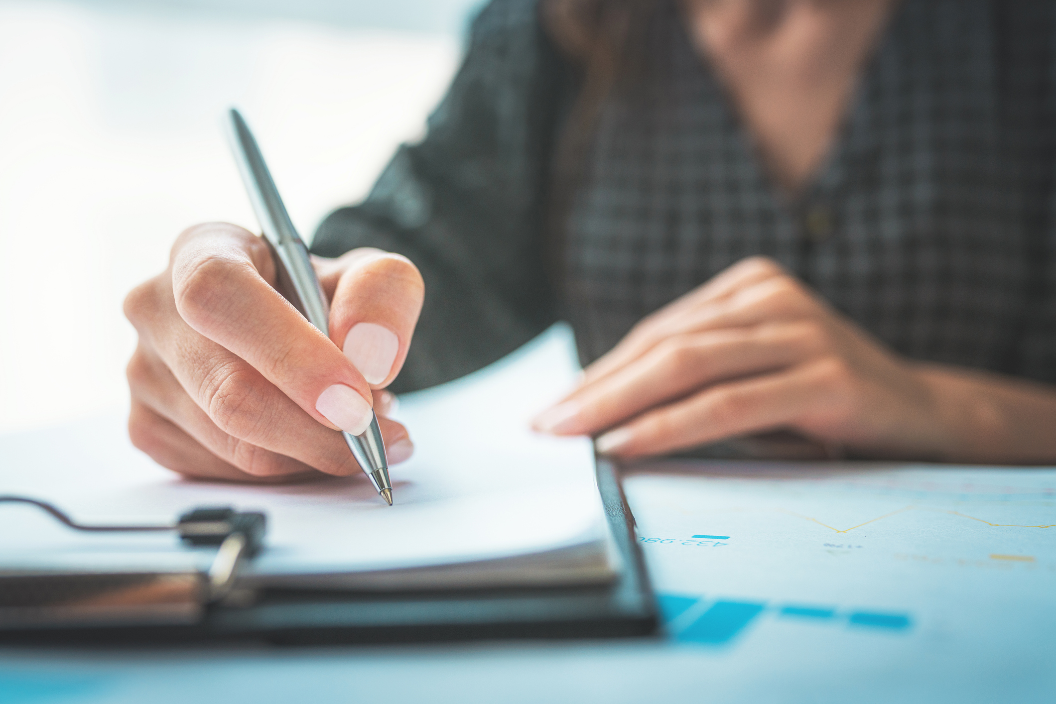 woman signing a printed ACH authorization form