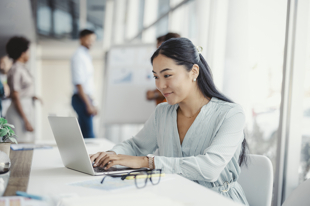 A businesswoman is busy processing electronic payments and managing merchant accounts on her computer